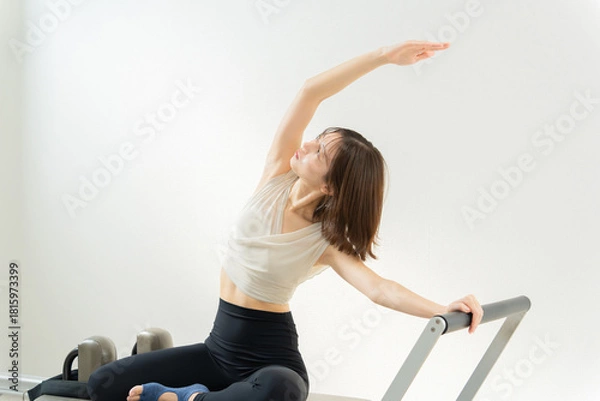 Obraz ピラティス女子 日本人女性がリフォーマーでポーズ