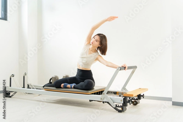 Obraz ピラティス女子 日本人女性がリフォーマーでポーズ