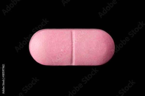Obraz close-up of a pink pill isolated on a black background.psd