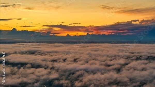 Obraz A high-altitude aerial photograph capturing a sunrise above a vast forest with golden morning mist drifting through the treetops