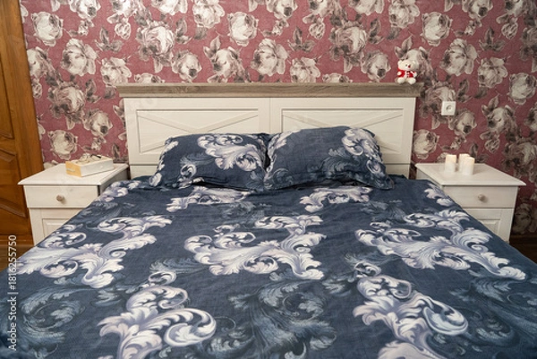 Obraz Floral bedroom scene with patterned bedding and soft lighting, creating a warm and inviting resting space.