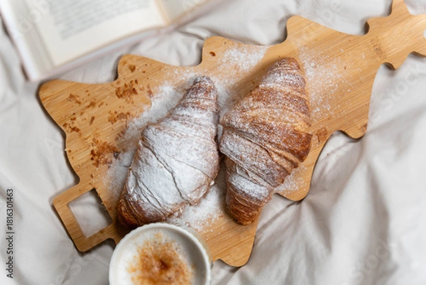 Obraz Top-down view of a romantic breakfast setup with croissants and coffee on rumpled white bed sheets.
