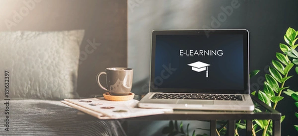 Obraz Miejsce pracy w złym pokoju bez ludzi, zbliżenie laptopa z napisem - e-learning na ekranie na stole. W pobliżu gazeta, filiżanka kawy. Edukacja na odległość, edukacja online, nauka. Nikt.