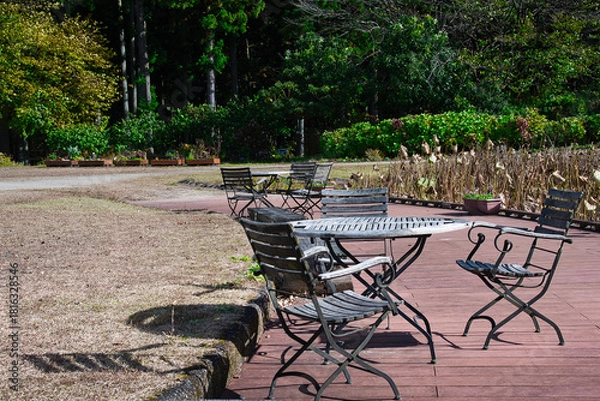 Obraz 秋晴れの空の下、公園に置かれた趣のあるテーブルとイス