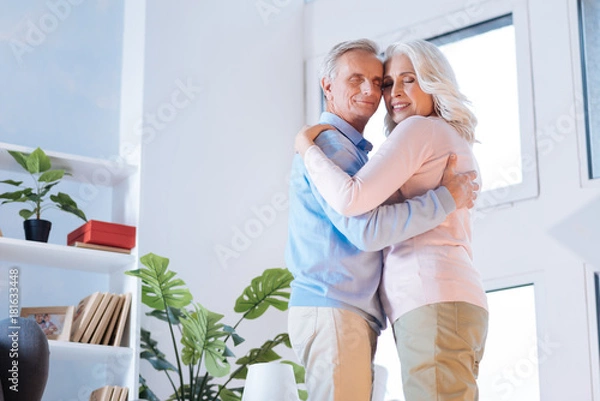 Obraz You are my one and only. Low angle shot of an adorable couple standing close to each other and smiling while embracing in a dance.
