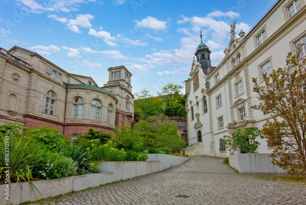 Fototapeta A striking contrast in architecture between Baroque-style Convent School and Revival-style Friedrichsbad Spa building