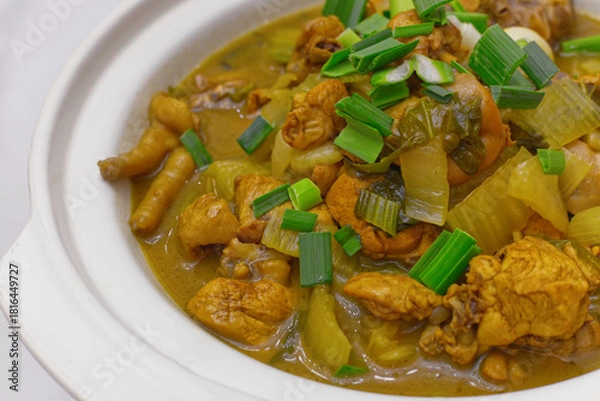 Fototapeta a rustic chicken stew or braised dish featuring pieces of chicken and celery in a savory yellow or turmeric-based sauce
