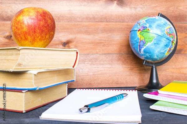 Fototapeta Studying concept, books, apple, globe and notebook on the wooden background.