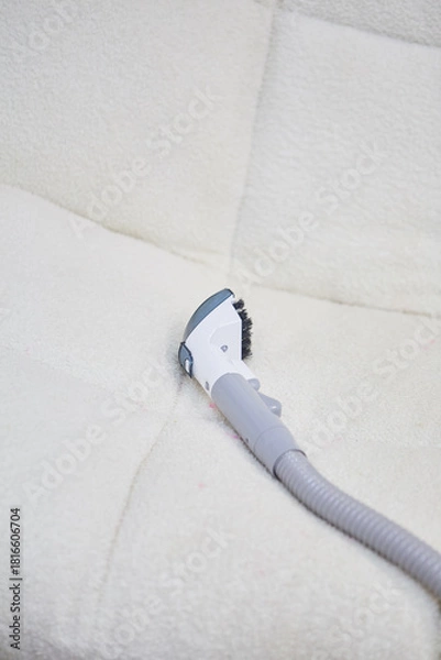 Obraz Vacuum cleaner on the white sofa. 