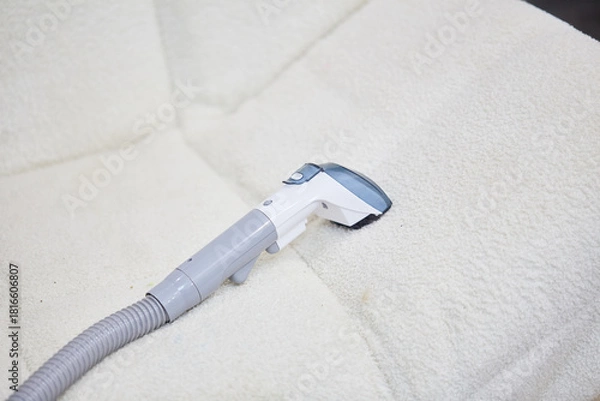 Obraz Vacuum cleaner on the white sofa. 