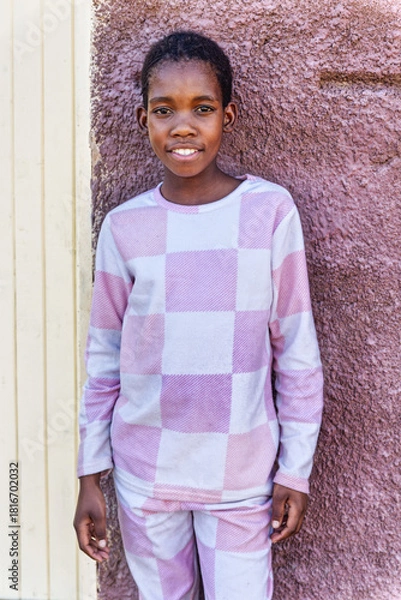 Obraz single african girl with braids in the village standing in front of her home