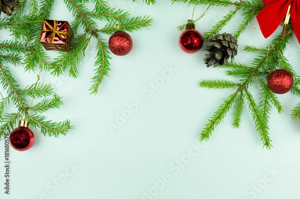 Fototapeta  Christmas tree branches with  cones, red balls and small presents, copy space