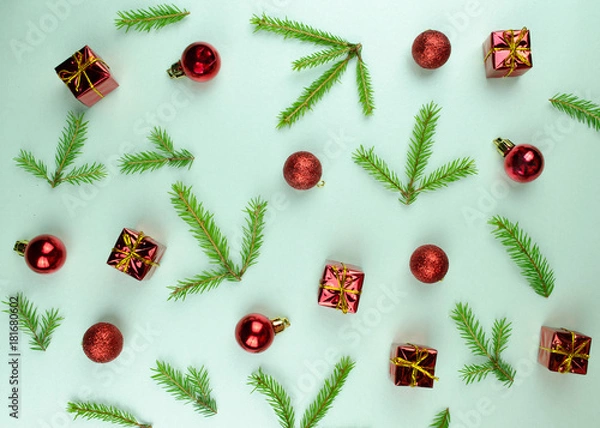 Fototapeta Christmas New Year pattern ornament with green branches, cones, red balls and small presents on mint background