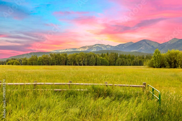 Obraz a farmer's field with mountains and sunset in the background in northwest Montana