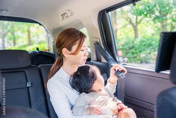 Obraz タクシーでシートベルトをする子連れのお母さん