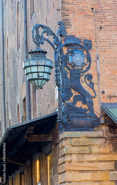 Obraz Ornate Street Lamp and Dragon Sign Over Piazza Del Nettuno in Historic Italian Street