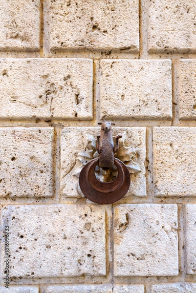 Obraz Rusty Iron Door Knocker on Weathered Stone Wall Creates Vintage Historic Exterior Look