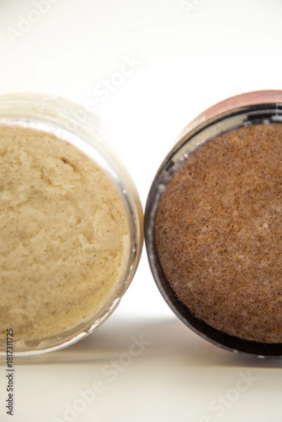 Obraz Jars of body scrub display contrasting textures, one creamy and one coarse, emphasizing natural ingredients and a soothing atmosphere for skincare lovers
