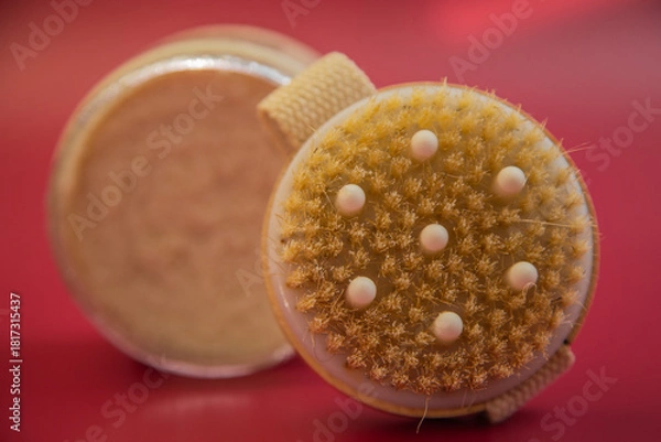 Obraz Exfoliating brush with soft bristles and a convenient strap, positioned on a bright red background, highlighting essential beauty tools for skincare routines