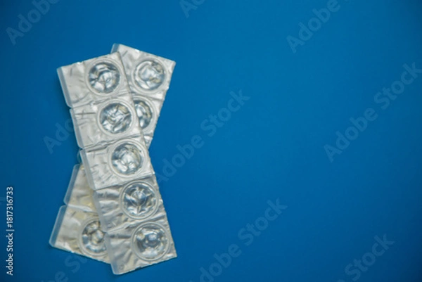 Obraz Packages of daily disposable contact lenses in a disposable protective case in which clear lenses float lie on the side on a blue background with space for text. The concept of ophthalmology, vision