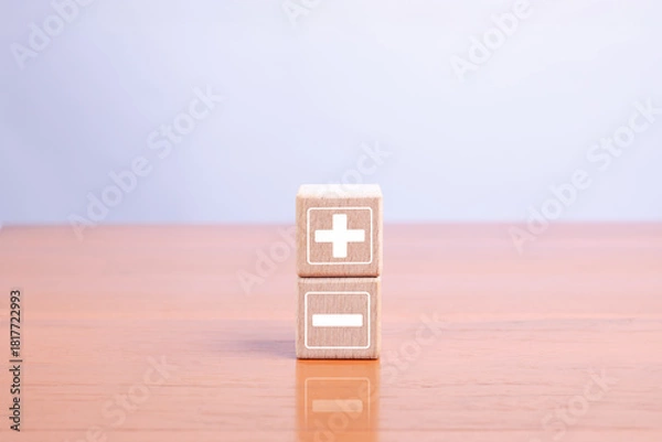 Fototapeta Wooden blocks with plus and minus symbols representing comparison, decision-making, pros and cons, and strategic choices in business, finance, and problem-solving concepts.