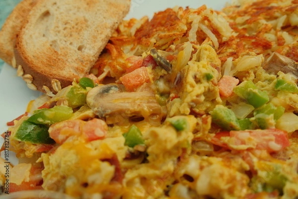 Fototapeta Delicious american breakfast egg scramble with bacon veggies and wheat toast
