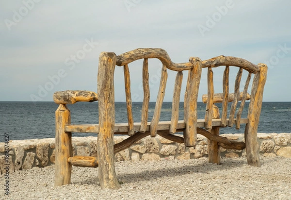 Fototapeta Rustic wooden bench overlooking the ocean with peaceful views of water and sky in a coastal setting