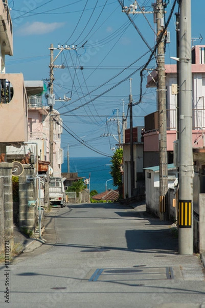 Obraz 奥にエメラルドグリーンの海の見える天気の良い町の路地裏の直線道