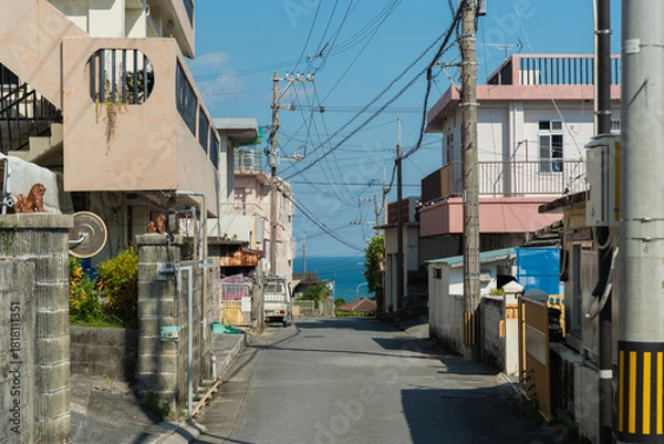 Obraz 奥にエメラルドグリーンの海の見える天気の良い町の路地裏の直線道