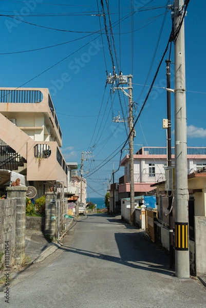 Obraz 奥にエメラルドグリーンの海の見える天気の良い町の路地裏の直線道