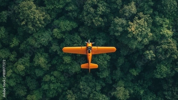 Fototapeta realistic small orange plane flying over a deep green forest, top down view
