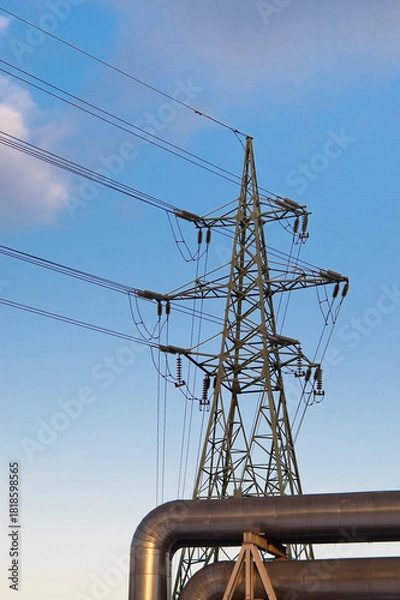 Fototapeta a pipeline and a power transmission tower against a blue sky.