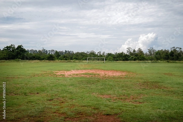 Fototapeta Abandoned football field with nobody and very bad grass, football field with poor ground conditions in the middle of nowhere