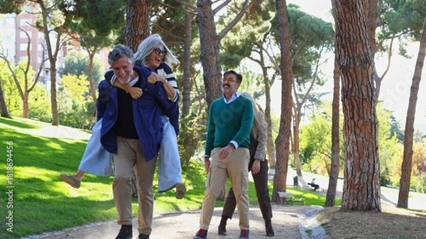Obraz Seniors friends enjoying piggyback ride in park