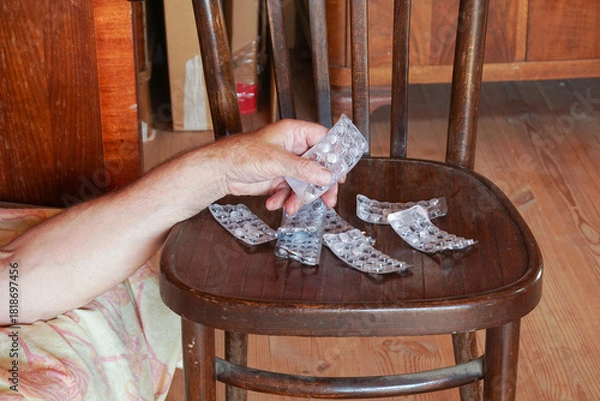 Obraz A man's hand holds an empty blister over several other empty packs.