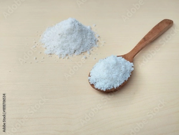 Fototapeta Pile of salt with wooden spoon on wooden table background 