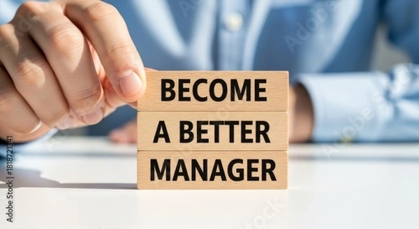 Obraz Become a Better Manager: A person holding a wooden block with the words BECOME A BETTER MANAGER written on it. This image represents the concept of self-improvement and development.
