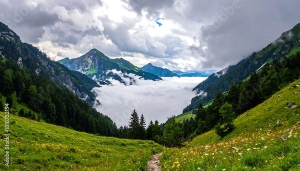 Fototapeta Green valley landscape with flowers, distant mountains, and a dense cloud inversion under a dramatic sky