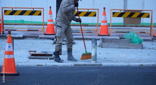Obraz 道路の工事現場で掃除する作業員の姿