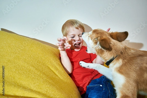 Obraz Cheerful boy playing an active game with his favorite dog