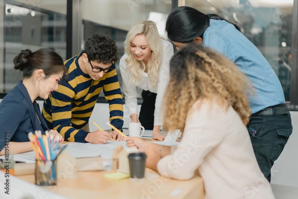 Obraz Diverse startup team actively collaborating and drawing on techn