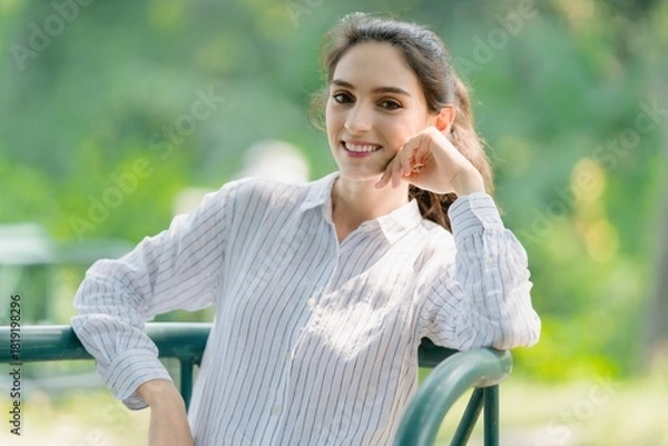 Obraz Thoughtful portrait of a smiling woman leaning on a railing, conveying confidence, approachability, and casual relaxation outdoors