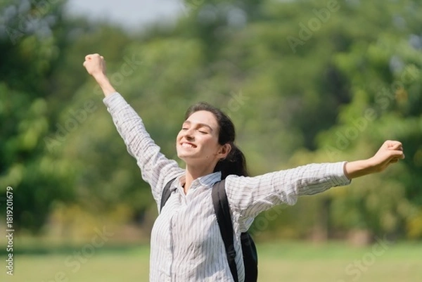 Fototapeta Woman standing outdoors with arms wide open, ecstatic joy, personal freedom, and embracing success and the future