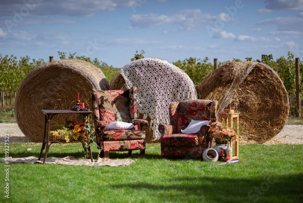 Obraz Rustic Outdoor Lounge Setup With Vintage Armchairs and Hay Bales
