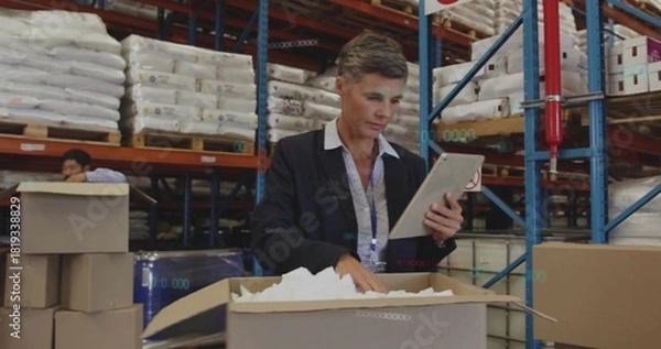 Obraz Inspecting manager in blazer and collared shirt using tablet, checking box at warehouse, pallets