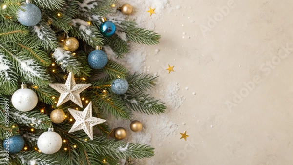 Fototapeta Christmas tree decorations concept. spruce branches in snow star ornaments, white blue gold baubles and glowing confetti on beige background with copyspace