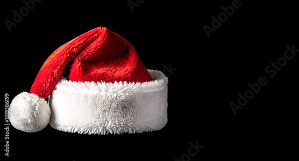 Fototapeta Gorro de Papá Noel rojo y blanco, aislado sobre fondo negro, para diseño navideño, felicitacion navideña, cartel de navidad, campañas y contenido creativo navideño