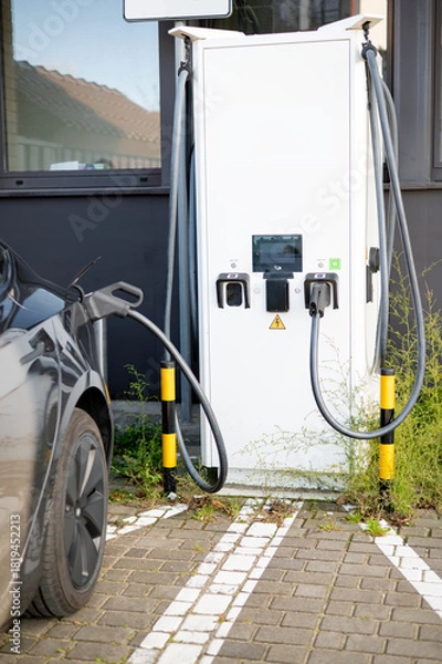 Fototapeta A man at a gas station takes disposable plastic gloves before refueling his car, showing attention to cleanliness, hygiene, and preparation for safe handling of fuel