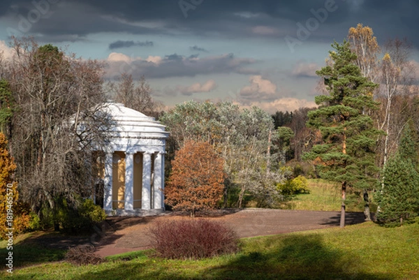 Fototapeta Temple of Friendship pavilion, designed as a rotunda decorated with 16 white Doric columns, bas-relief medallions, and light stucco molding, in Pavlovsk City Park on a sunny autumn day.