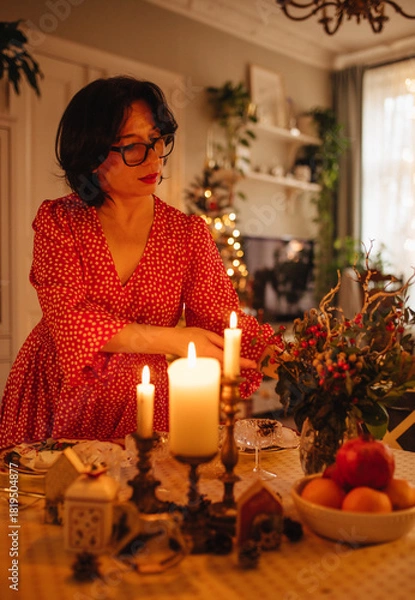 Obraz A woman is setting the table for Christmas dinner